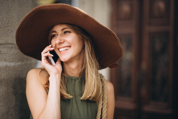 Bezpłatne zdjęcie kobieta w kapeluszu na wakacje rozmawia przez telefon