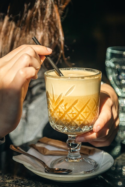 Bezpłatne zdjęcie kobieta w kawiarni pije cappuccino ze szklanego kubka