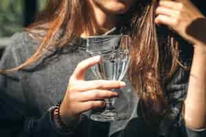 Bezpłatne zdjęcie kobieta w kawiarni trzyma szklankę wody w ręku