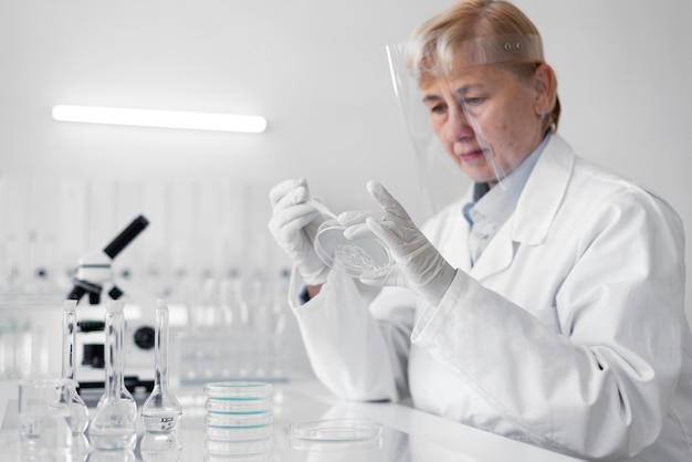 Bezpłatne zdjęcie kobieta w laboratorium robienie eksperymentów