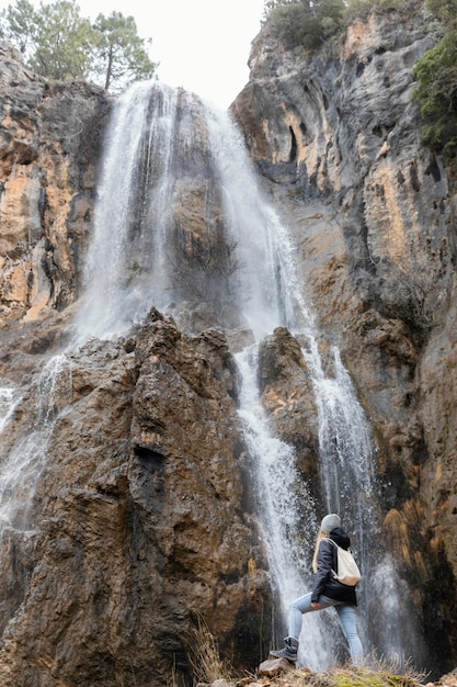 Bezpłatne zdjęcie kobieta w naturze przy wodospadzie