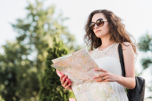 Kobieta w okularach przeciwsłonecznych z mapą