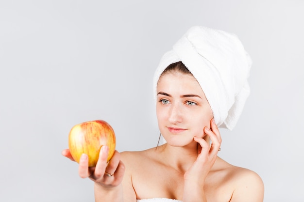 Bezpłatne zdjęcie kobieta w ręcznik trzyma jasne jabłko
