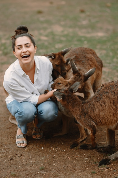 Bezpłatne zdjęcie kobieta w rezerwie bawi się kangurem