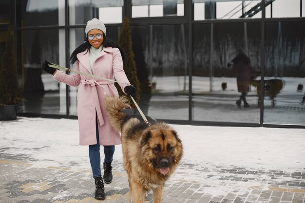 Kobieta w różowym płaszczu z psem
