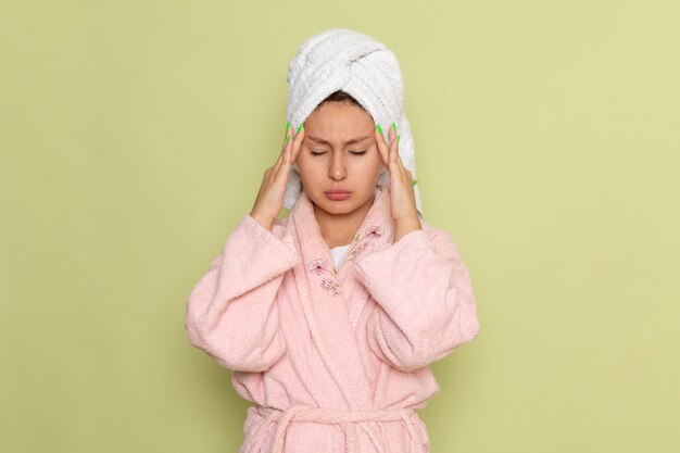 kobieta w różowym szlafroku o silnym bólu głowy
