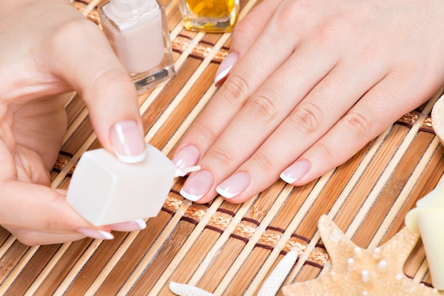 Kobieta W Salonie Paznokci Odbiera Manicure Przez Kosmetyczkę. Koncepcja Zabiegów Kosmetycznych.