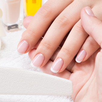 Kobieta w salonie paznokci odbiera manicure przez kosmetyczkę. koncepcja zabiegów kosmetycznych.