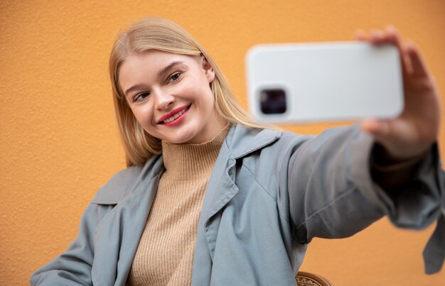 Kobieta w średnim ujęciu robi selfie