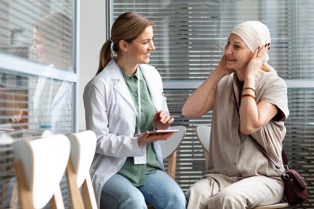 Bezpłatne zdjęcie kobieta w średnim wieku z rakiem skóry rozmawia ze swoim lekarzem