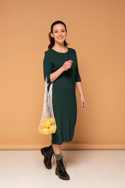 Kobieta w ubranie niosące torbę wielokrotnego użytku żółwia
