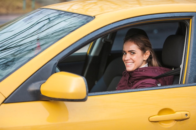 Bezpłatne zdjęcie kobieta w żółtym samochodzie