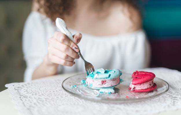 Bezpłatne zdjęcie kobieta wkłada widelec w kanapkę z lodami na talerzu nad stołem
