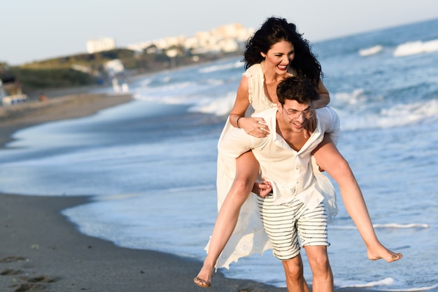 Kobieta wspiął się na plecy mężczyzny na plaży