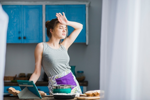 Bezpłatne zdjęcie kobieta wyciera czoło w kuchni
