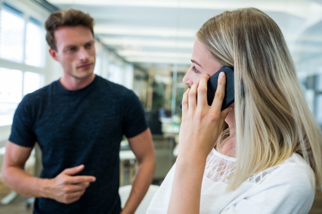 Kobieta Wykonawczej Rozmawia Na Telefon Komórkowy W Czasie Interakcji Z Kolegą