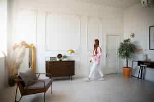 Bezpłatne zdjęcie kobieta wykonująca codzienne czynności w minimalistycznie urządzonym pokoju