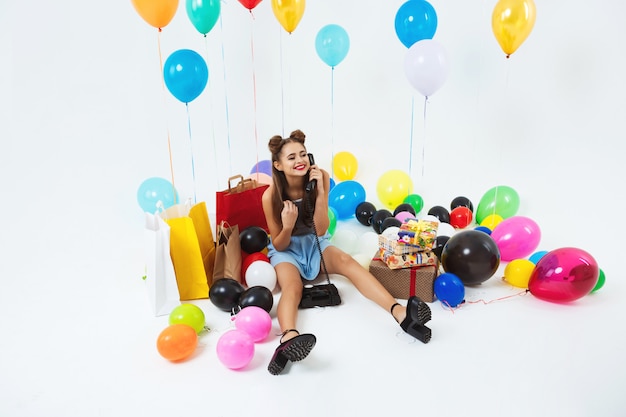 Kobieta wystawiająca urodziny, stting z dużymi balonami i prezentami