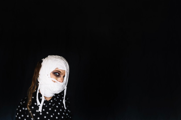 Kobieta z bandaże wokół głowy w ciemności