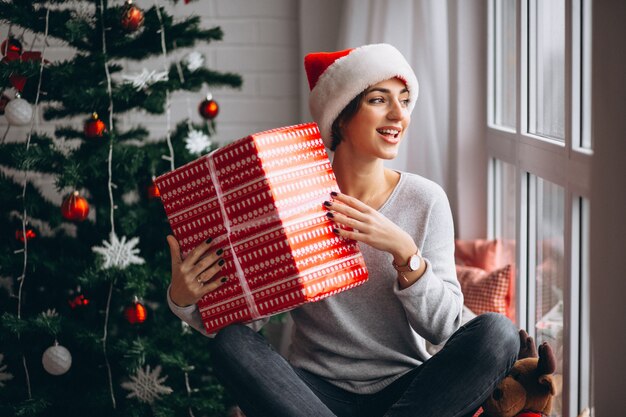 Kobieta z Bożenarodzeniowymi teraźniejszość choinką