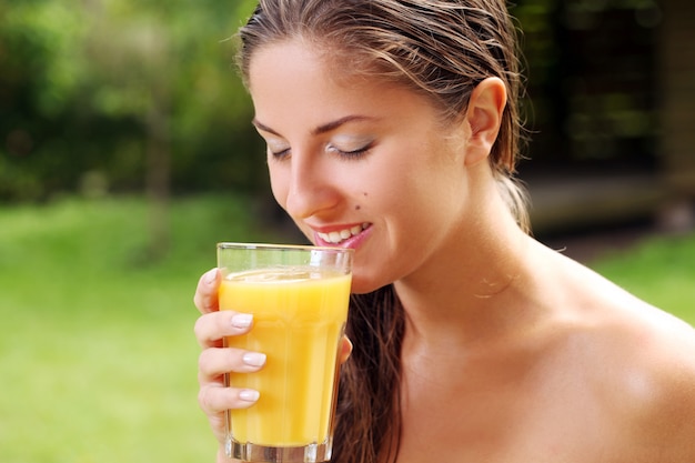 Kobieta z dużą szklanką świeżego soku pomarańczowego