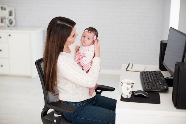 Kobieta z dzieckiem przy komputerem
