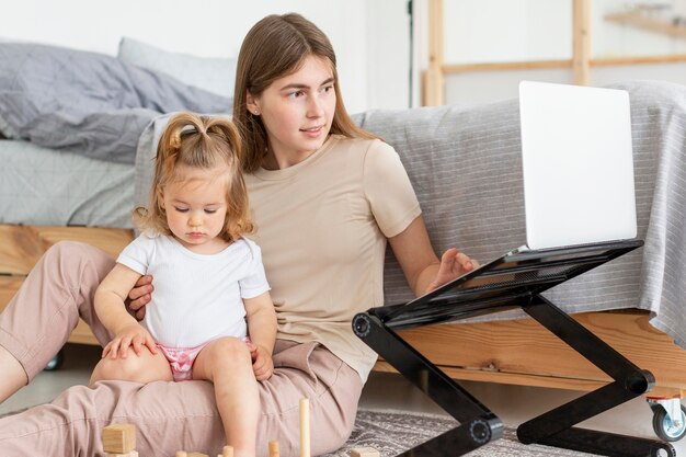 Kobieta z dziewczyną pracuje na laptopie