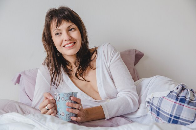 Kobieta z kawą na łóżku zamknąć widok