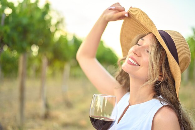 Kobieta z lampką wina marzycielski wygląd Szczęśliwa dziewczyna pije wino.
