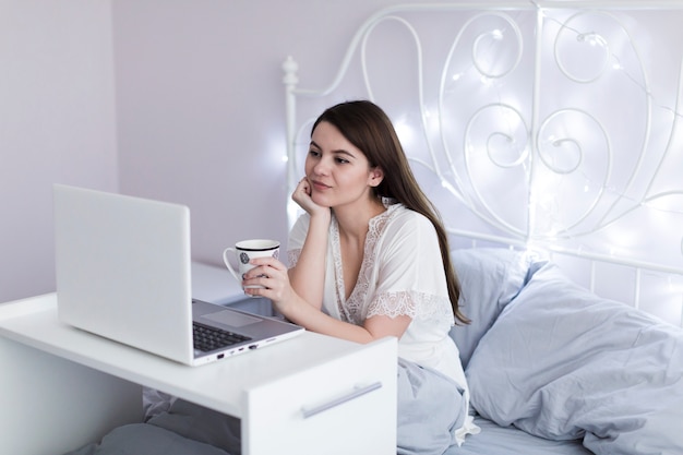Kobieta z laptopem w łóżku