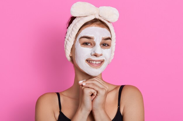 Kobieta z oczyszczającą białą maską na twarzy