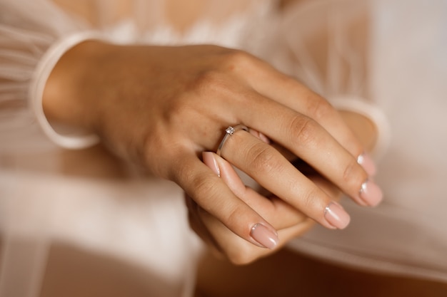 Kobieta z pierścionkiem zaręczynowym z diamentem i pięknym manicure'em