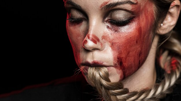Kobieta z plecionymi włosami i krwawym makijażem