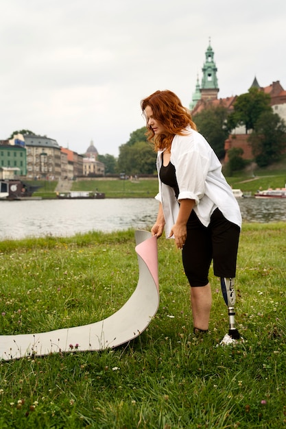 Bezpłatne zdjęcie kobieta z protezą nogi robi jogę