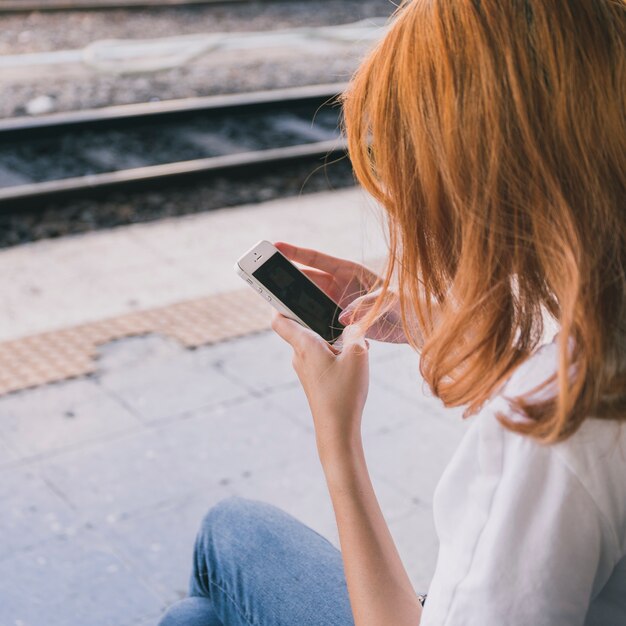 Kobieta z smartphone na staci kolejowej