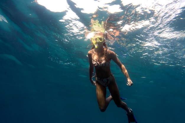 Kobieta z sprzęt do nurkowania pływanie w oceanie