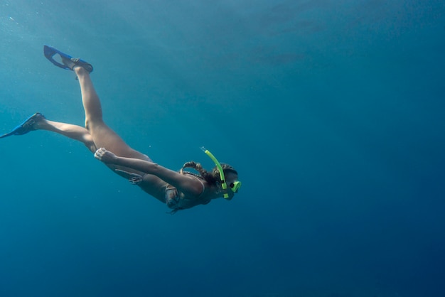Kobieta z sprzęt do nurkowania pływanie w oceanie