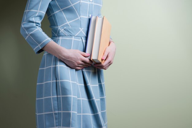 Kobieta z sukienka w kratkę posiadania dwóch książek