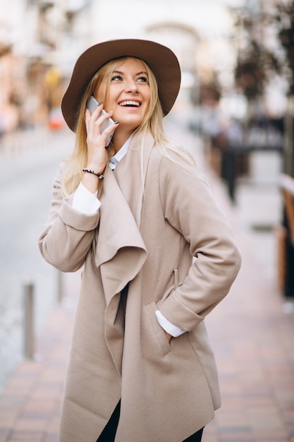 Bezpłatne zdjęcie kobieta z telefonem w kapeluszu na zewnątrz ulicy