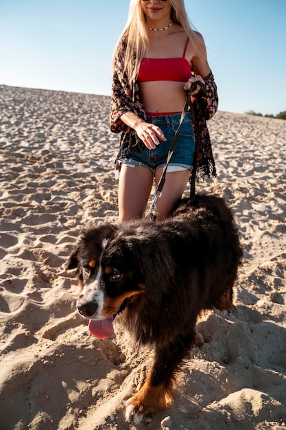 Kobieta z uroczym psem na plaży widok z przodu