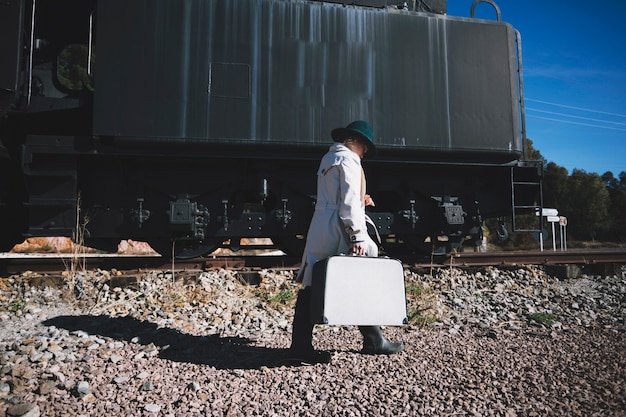 Bezpłatne zdjęcie kobieta z walizką chodzić do pociągu