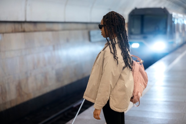 Bezpłatne zdjęcie kobieta z widokiem z boku czeka na metro