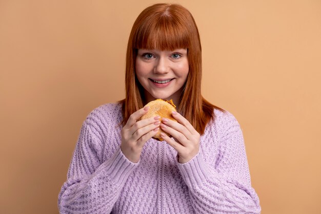 Kobieta z zaburzeniami odżywiania próbuje zjeść burgera