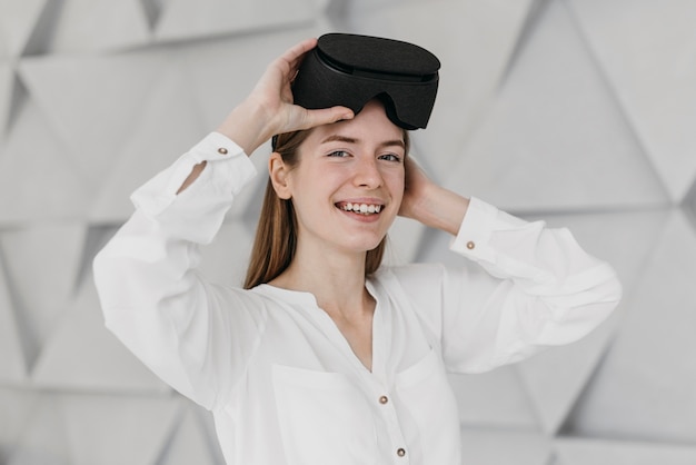 Bezpłatne zdjęcie kobieta za pomocą zestawu słuchawkowego wirtualnej rzeczywistości w pomieszczeniu