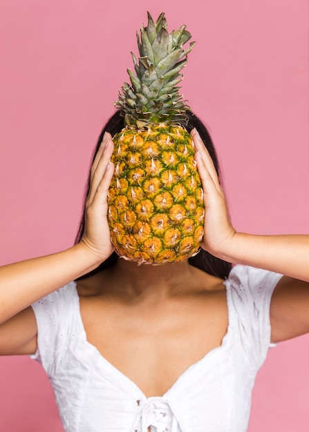 Kobieta zasłaniając twarz z ananasem