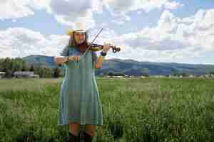 Bezpłatne zdjęcie kobieta ze skrzypcami szykuje się do koncertu muzyki country