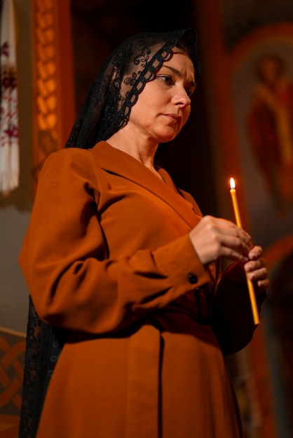 Bezpłatne zdjęcie kobieta ze świecą w kościele