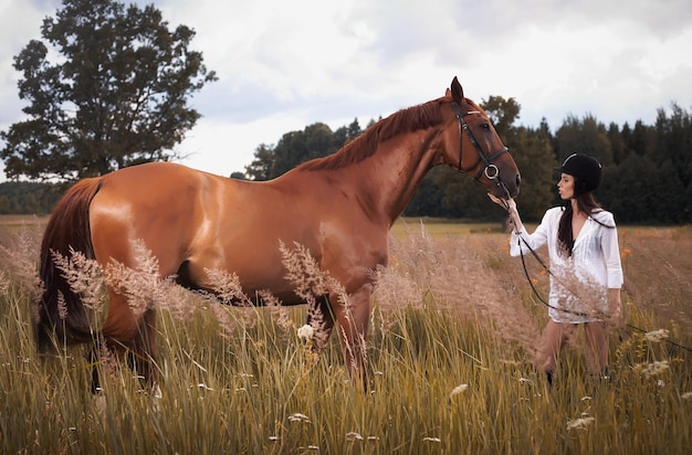 Kobieta ze swoim brązowym koniem.