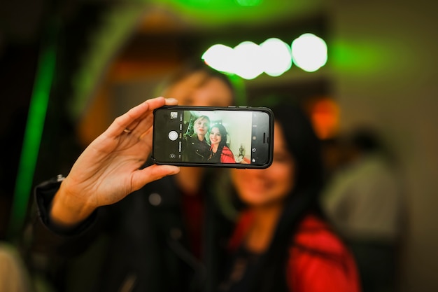 Bezpłatne zdjęcie kobiety biorące selfie w telefonie komórkowym