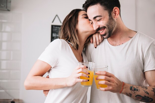 Kobiety całowania mężczyzna podczas gdy cieszący się sok